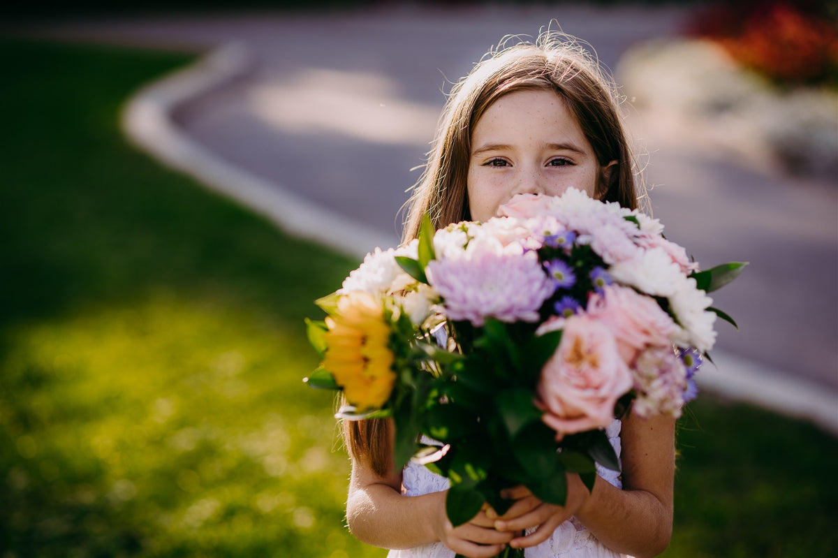 Smiling girl holding a fresh bouquet of pastel flowers