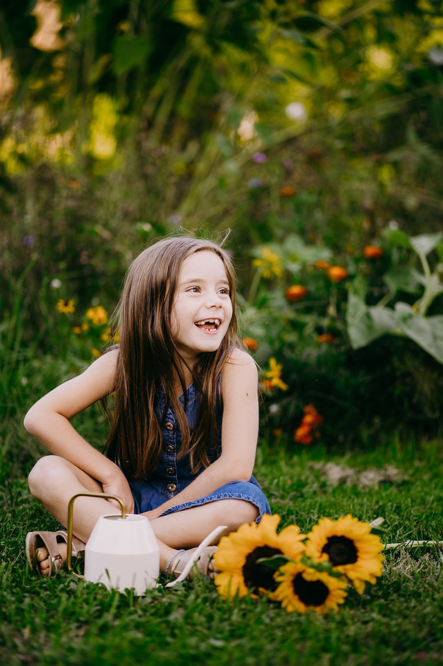Girl laughing on the grass with sunflowers