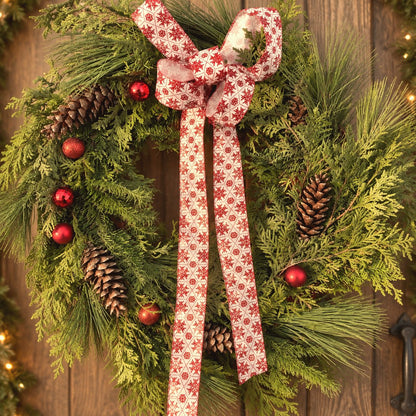 Couronne de Noël faite à la main avec cocottes, boules rouges et ruban à flocons